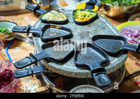 Familienessen auf Raclette Stockfoto