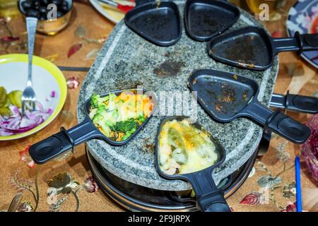 Familienessen auf Raclette Stockfoto