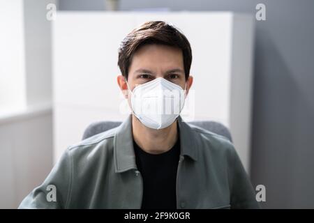 Tragen einer medizinischen KN95 Covid Gesichtsmaske im Büro Stockfoto