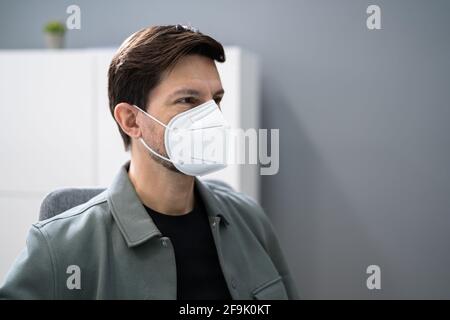 Tragen einer medizinischen KN95 Covid Gesichtsmaske im Büro Stockfoto