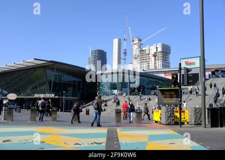 London, England. April 2021. Fußgänger vor der Stratford Station im Osten Londons, während die Hitzewelle die Hauptstadt trifft. Eine Punktmatrix-Informationsanzeige zeigt „Covid Risk is High in Newham“ an. Bradley Stearn / Alamy Live News Stockfoto