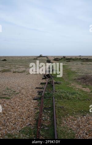 Aus den Schienen. Verrostete Schienen erinnern an die Zeit, als Dungeness Beach ein Hub für Fischer war. Stockfoto