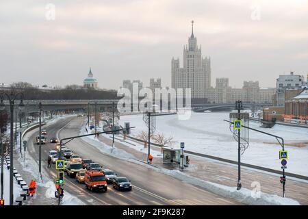 Moskau, Russland - 17. Januar 2021: Blick auf den Moskvoretskaja-Damm, Autos und einen Wolkenkratzer am Kotelnicheskaya-Damm an einem frostigen Wintermorni Stockfoto