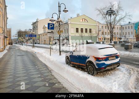 Moskau, Russland - 17. Januar 2021: Blick auf die Pyatnitskaya-Straße und ein schneebedecktes Auto auf dem Parkplatz an einem frostigen Wintermorgen nach schwerem Schnee. Stockfoto