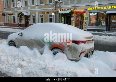 Moskau, Russland - 17. Januar 2021: Blick auf die Pyatnitskaya-Straße und ein schneebedecktes Auto auf dem Parkplatz an einem frostigen Wintermorgen nach schwerem Schnee. Stockfoto