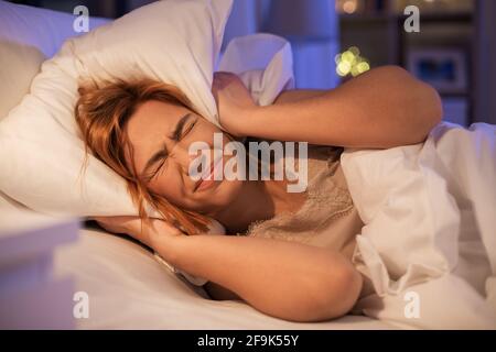 Verärgerte Frau, die nachts an Schlaflosigkeit leidet Stockfoto