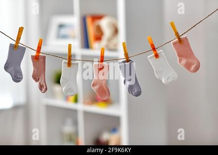 Kleine Socken für Mädchen auf Wäscheleine zu Hause Stockfoto