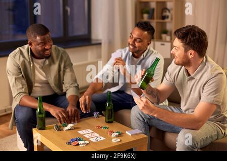 lächelnd männlichen Freunden Spielkarten zu Hause Stockfoto