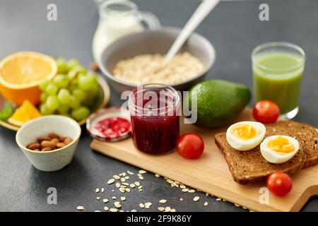 Marmelade, Toastbrot, Eier, Avocado, Kirschtomaten Stockfoto