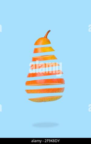 Minimale kreative Idee mit schwebenden reifen Birnen auf pastellblauem Hintergrund. Vitamine, gesunde Ernährung Konzept. Birne in Scheiben, die in der Luft schwebt. Stockfoto