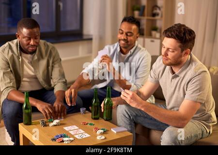 lächelnd männlichen Freunden Spielkarten zu Hause Stockfoto