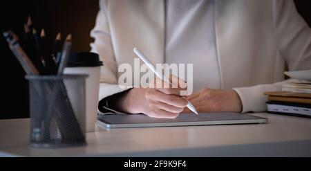 Nahaufnahme Geschäftsfrau hält Stift Zeichnung auf dem digitalen Tablet Am Arbeitsplatz Stockfoto