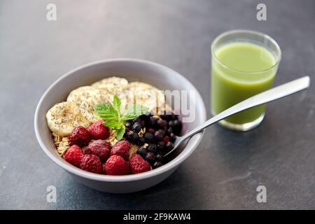 Cerealien-Frühstück mit Beeren, Banane und Löffel Stockfoto