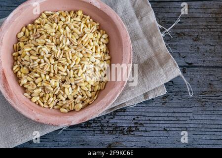 Ungekochte Weizenkörner, die in frankreich auf rustikalem Hintergrund angebaut werden Stockfoto