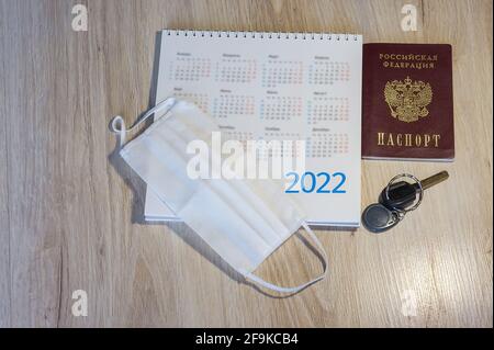 Russischer Reisepass und Kalender. Medizinische Maske und Kalender 2022. Schlüssel und Reisepass auf dem Tisch. Stockfoto