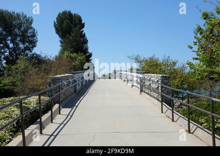 IRVINE, KALIFORNIEN - 16 APR 2021: Fußgängerbrücke über den Alton Parkway, der den Mike ward Community Park und den Woodbridge South Lake verbindet. Stockfoto