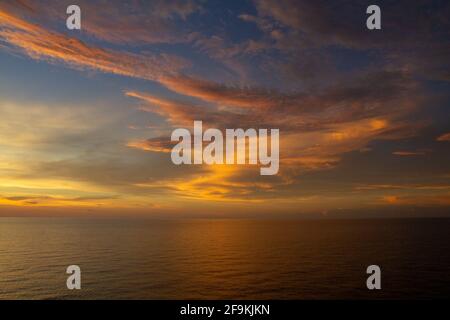 Wunderschöner Blick auf das Meer mit einem dramatischen, wolkigen Himmel und goldenem Sonnenuntergang Stockfoto