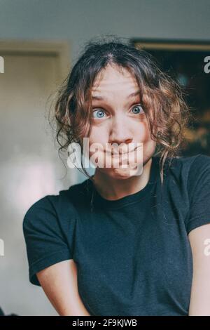 Mädchen macht lustige Gesicht mit ihrem Gesicht in ihrem Zimmer Stockfoto