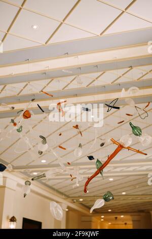 A multi-colored blown glass chandelier hangs from the ceiling with invisible threads. Stockfoto