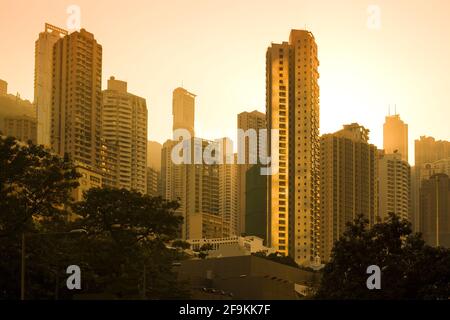 Sonnenuntergang hinter der Skyline von Wohngebäuden im Wohnviertel Chung Wan im Zentrum von Hongkong, China. Stockfoto