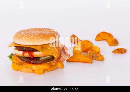 Köstlicher Burger mit geschmolzenem Käse und gebratenen Kartoffelscheiben Stockfoto