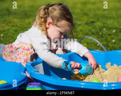 Kleinkind spielt in einer Sandgrube, Großbritannien Stockfoto