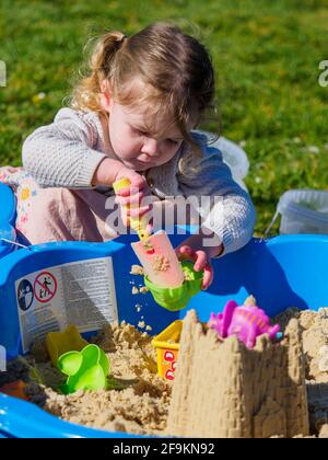 Kleinkind spielt in einer Sandgrube, Großbritannien Stockfoto