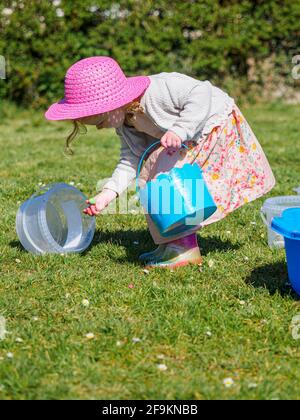 Kleinkind auf Ostereiersuche im Garten, Großbritannien Stockfoto