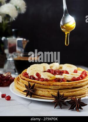 Honig gießt über den Stapel von Pfannkuchen/Crepes Stockfoto