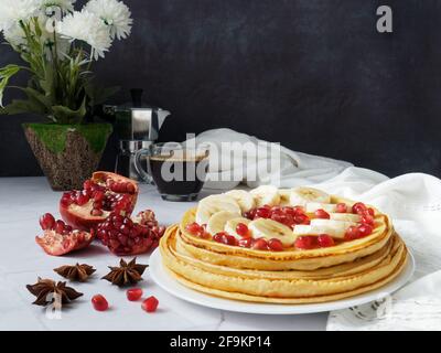 Stapel von Pfannkuchen mit Banane und Granatapfel Stockfoto