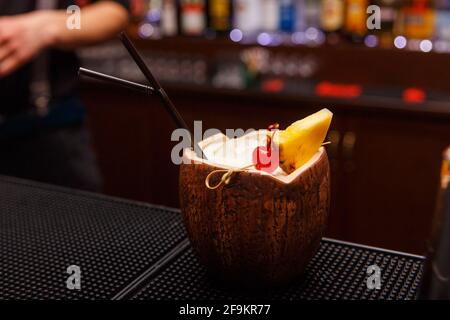 Exotischer alkoholischer Cocktail in Kokosnuss, der auf der Bar zart steht. Stockfoto