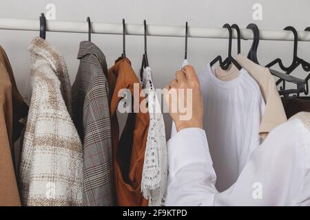 Weibliche Mode Stylistin wählt Kleidung auf stilvolle Geländer in Dressing Zimmer Stockfoto
