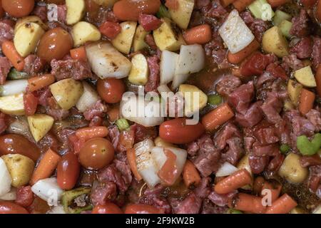 Im Ofen gebackenes Rindfleisch in einer Auflaufform eintoben. Hat Tomaten, Zwiebeln, Rindfleisch, Sellerie-Karotten und Kartoffeln. Stockfoto