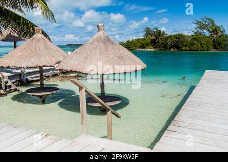 Tisch und Sonnenschirm in einem Wasser auf Caye Caulker Island, Belize Stockfoto