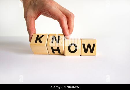 Know-how-Symbol. Geschäftsmann dreht Würfel und ändert das Wort "wie" zu "wissen". Schöner weißer Tisch, weißer Hintergrund. Speicherplatz kopieren. Business und Know Stockfoto