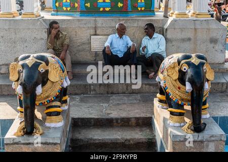 Mysuru, Karnataka, Indien - Januar 2019: Männer bei Gesprächen im Freilichtpark, der mit Vintage-Skulpturen von Elefanten in der Stadt geschmückt ist Stockfoto