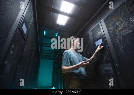 Porträt einer Militärfrau mit niedrigem Winkel, die beim Einrichten von Servern im Rechenzentrum ein Bedienfeld verwendet, Kopierplatz Stockfoto