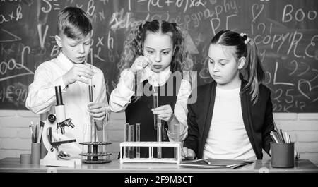 Schüler studieren Chemie in der Schule. Kinder genießen chemische Experimente. Chemische Substanz löst sich in einem anderen. Erkunden ist so aufregend. Chemische Reaktion Stockfoto