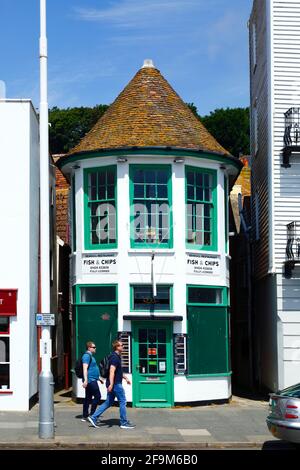 Junge Männer gehen am Seagull Fish and Chips Restaurant am Meer vorbei, Hastings, East Sussex, England Stockfoto