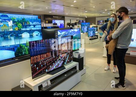 Die Menschen sehen die Beerdigung des Duke of Edinburgh im nationalen Fernsehen, während sie in einem John Lewis Kaufhaus in der Oxford Street, London, Großbritannien, einkaufen Stockfoto