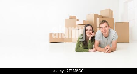 glückliches junges Paar am Boden in ihrem neuen Zuhause Stockfoto