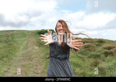 Porträt von lächelnden schönen jungen Frau, die Kamera und Zeigt ihre Handflächen der Kamera Stockfoto