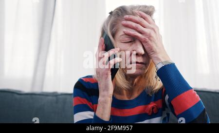 Verzweifelte alte Frau, die mit Tränen telefoniert. Hochwertige Fotos Stockfoto