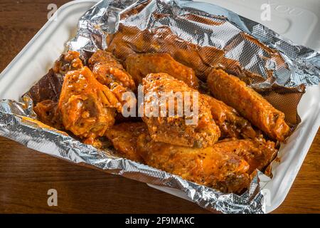 Würzige Hähnchenflügel herausnehmen Stockfoto