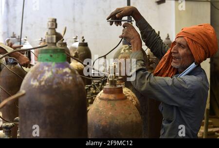 Prayagraj, Indien. April 2021. Ein Arbeiter füllt medizinische Sauerstoffflaschen, die in den COVID-19-Krankenhäusern in Prayagraj, Indiens nördlichem Bundesstaat Uttar Pradesh, verwendet werden, 19. April 2021. Indiens COVID-19-Zahlen übertrafen die 15-Millionen-Marke und erreichten am Montag 15,061,919, was die neuesten Daten des Bundesgesundheitsministeriums offenbarte. In den letzten 24 Stunden gab es einen Anstieg von 273,810 COVID-19-Fällen. Dies ist der dritte Tag in Folge, an dem das Land einen einzigen Anstieg von über 250,000 neuen Fällen erlebt hat. Quelle: Str/Xinhua/Alamy Live News Stockfoto