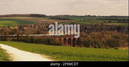 Ein Blick über das Darent Valley bei Eynsford Richtung Der Eisenbahnviadukt mit einem vorbeifahrenden Zug und der Dorf im Hintergrund und Felder Stockfoto
