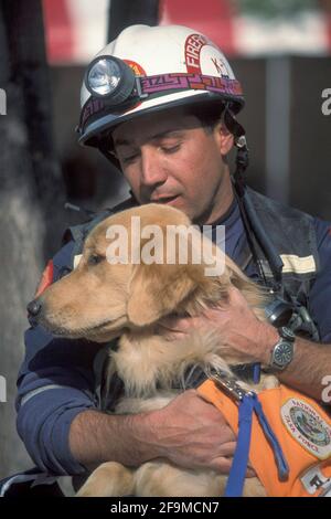 Oklahoma City, OK, USA. April 2021. Ein Feuerwehrmann stottert sein Rettungstier in der Innenstadt von Oklahoma City, während die Arbeiter nach dem Bombenanschlag vom 19. April 1995, bei dem 168 Menschen ums Leben kamen, darunter mehrere Kinder, weiterhin tagelang durch die Trümmer des Murrah Federeal Building sieben. Der Armeeveteran Timothy McVeigh wurde für die Morde verurteilt. Quelle: Bob Daemmrich/ZUMA Wire/Alamy Live News Stockfoto