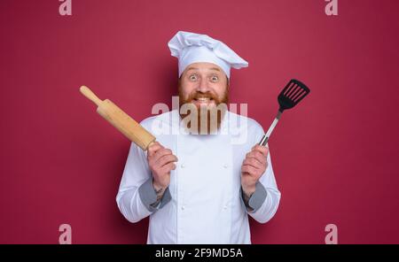 Mann Koch mit glücklich und überrascht Ausdruck. burgunder Farbe Hintergrund Stockfoto