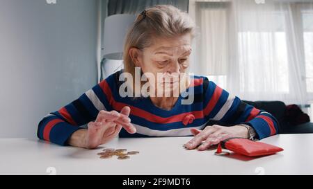 Alte pensionierte Frau, die verzweifelt Münzen zählte, die übrig geblieben sind. Hochwertige Fotos Stockfoto