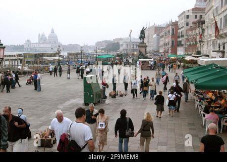 Menschen an der Promenade in Venedig, Italien. Denkmal von Victor Emmanuel II. Im Zentrum. Stockfoto